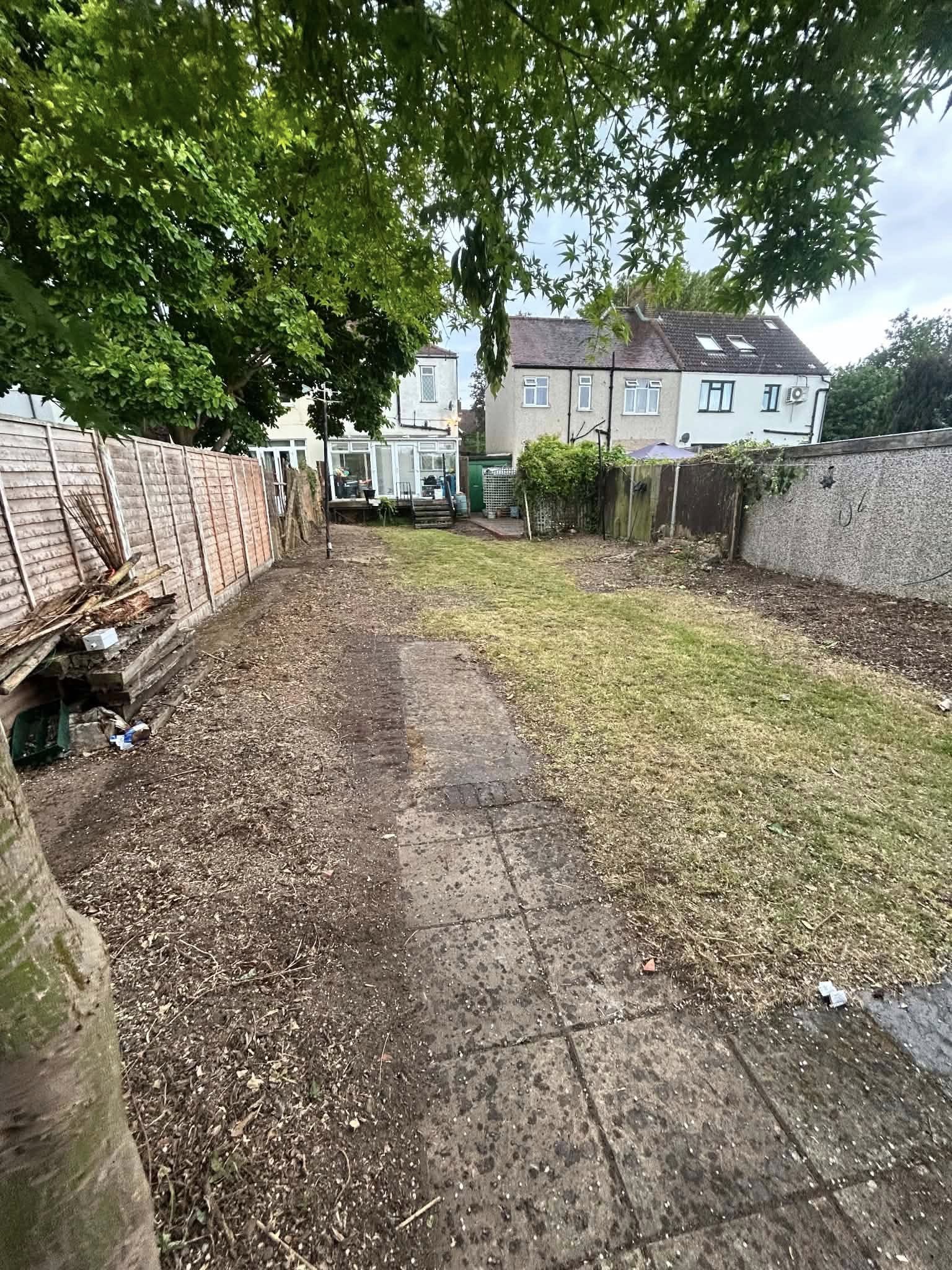 Before: overgrown residential garden with concrete paving and fencing
