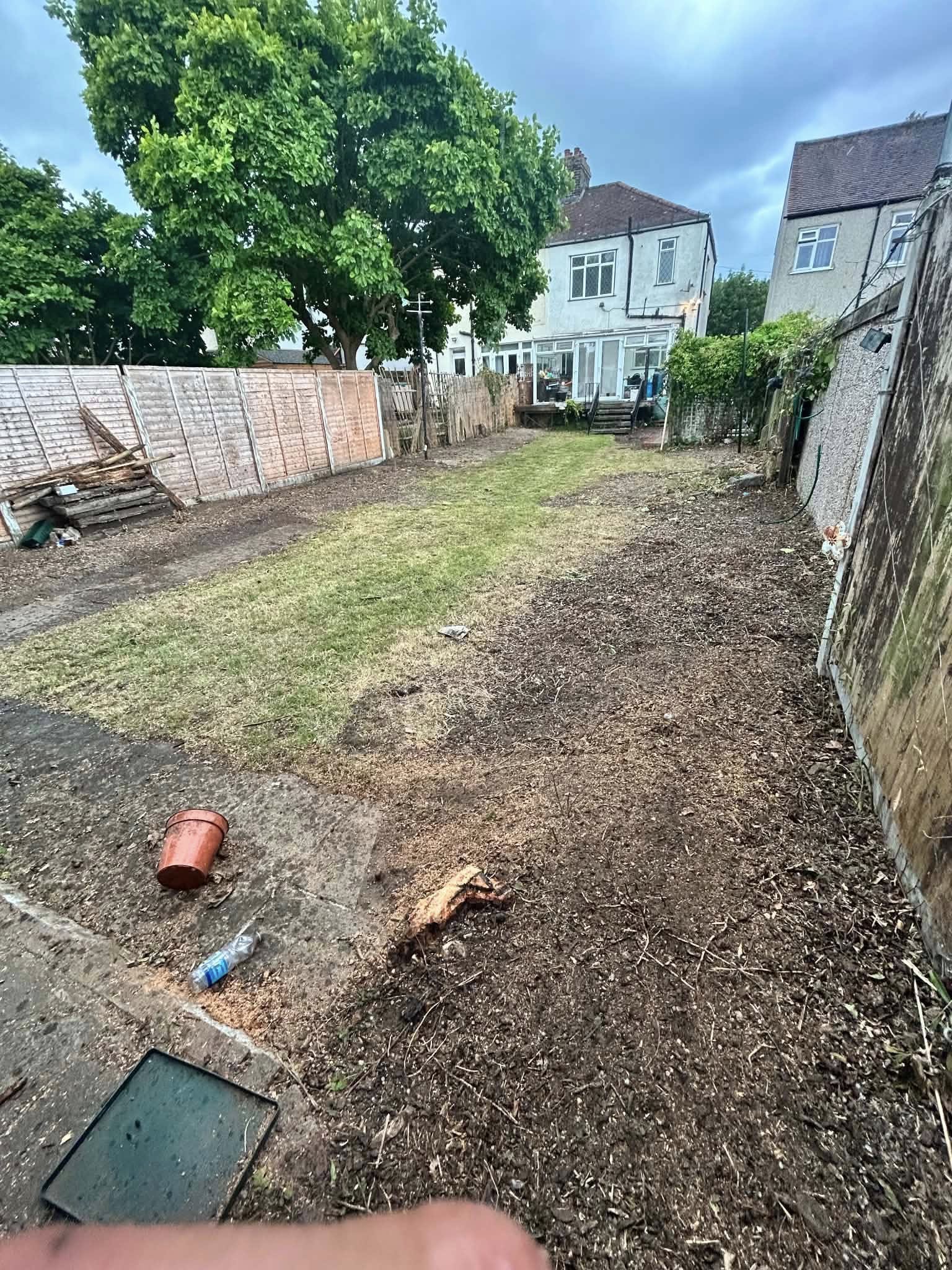 Before: overgrown garden with debris and disused fencing